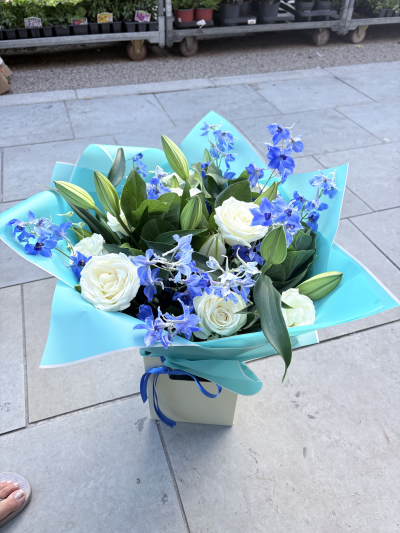 Blue bliss - White roses tied with lily’s and blue delphiniums